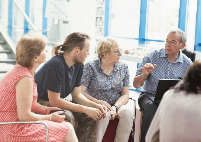 group of mixed aged men and women sitting discussing