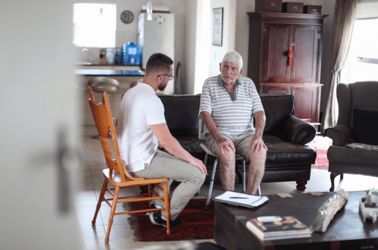 two men sat down talking in a home